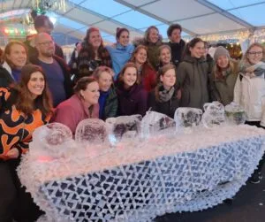 Collega’s poseren trots met hun ijskunstwerken tijdens een creatieve workshop ijssculpturen Scheveningen als uniek bedrijfsuitje
