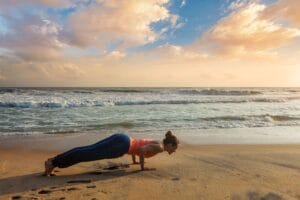 Collega geniet van een mindful sessie Yoga in Scheveningen op het strand tijdens een ontspannen en verbindend bedrijfsuitje.